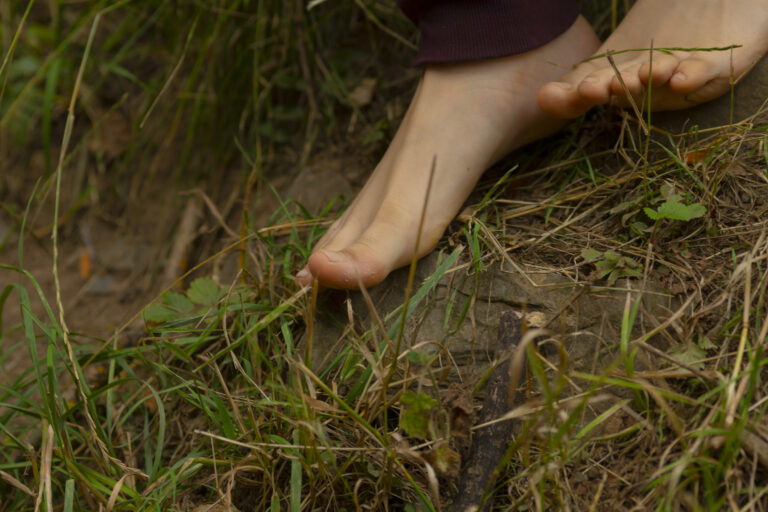 Piedi scalzi sull’erba come esempio di glimmer e segnale di sicurezza per il sistema nervoso