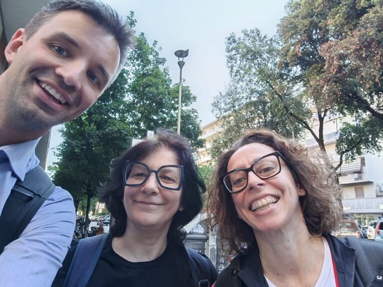Tre persone sorridenti all’aperto, immagine che accompagna un articolo sulle amicizie adulte e sui legami che cambiano nel tempo.
